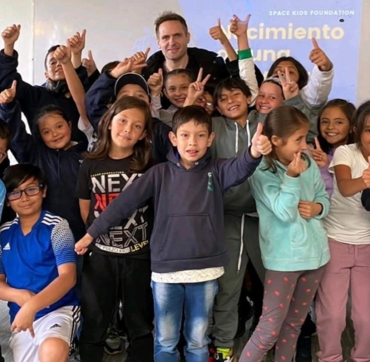 Chris Meniw rodeado de niños sonriendo en Space Kids