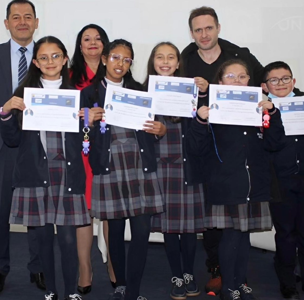 Estudiantes uniformadas con diplomas